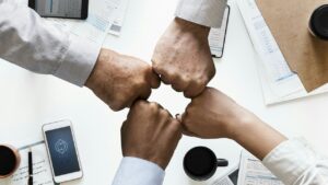拳を突き合わせて協力の意思を示すチーム